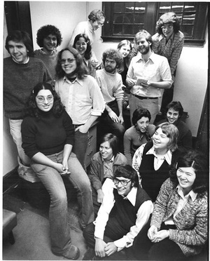 Members of The Daily Orange staff in the 1970s are shown in The D.O.'s previous home on East Adams Street in Syracuse. Pictured are Mike Kelly (far left, in trash can), Rose Ciotta (sitting on desk in front), Mark Bromberg (on the right side of Ciotta), Phil Sneiderman (in front on floor with glasses), Dinah Eng (right of Sneiderman), Dena Bunis (behind Eng), Tony Pruzinsky (standing with notebook), Gary Myers (to left of Pruzinsky), Christine Kukka (behind Pruzinsky's right shoulder), Joe Van Eaton (to right of Kukka), Barbara Riegelhaupt (to right of Van Eaton) and Kevin Riordian (to right of Riegelhaupt, behind Kelly). 